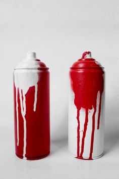 two red and white canisters sitting next to each other on a white surface