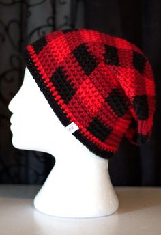 a white mannequin head wearing a red and black hat