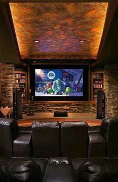 a home theater with leather couches and a large screen