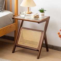 a small wooden table with a lamp next to it