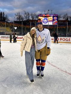 a man and woman are standing on an ice rink