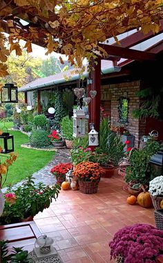 a patio with lots of flowers and plants on the ground next to a brick walkway