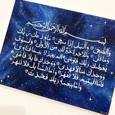 an arabic calligraphy written in two different languages on a blue background with stars and clouds