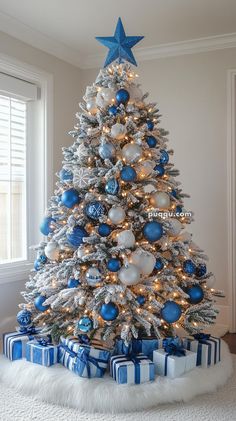 a white christmas tree with blue and silver ornaments