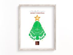 a green christmas tree with a star on top in a white frame against a wall