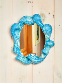 a mirror hanging on the side of a wooden wall next to a white painted door