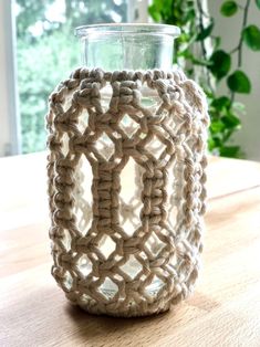 a crocheted vase sitting on top of a wooden table