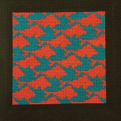 an orange and blue cross stitch pattern on black fabric