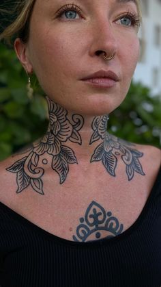 a woman with tattoos on her neck and chest