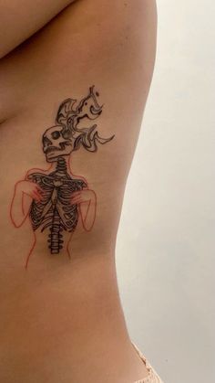 a woman's stomach with a skeleton tattoo on the side, and a horse behind her