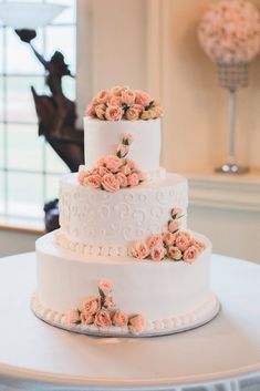 three tiered wedding cake with pink flowers on top