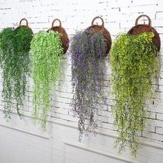 four hanging baskets with flowers in them on the wall next to a brick wall that says, not include the flower basket