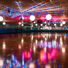 an empty dance floor with lights hanging from the ceiling and disco balls on the ceiling