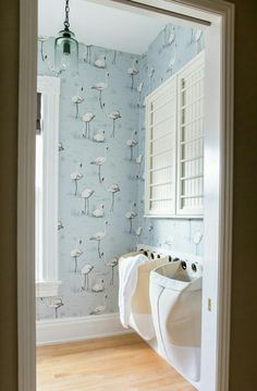 an open door leading to a bathroom with flamingos on the wall