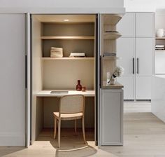 an open closet with a desk and chair in the corner, next to a kitchen counter