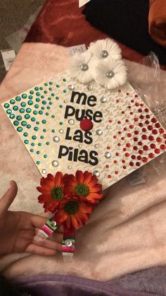 someone is holding some flowers on top of a piece of paper that says me puse las piias