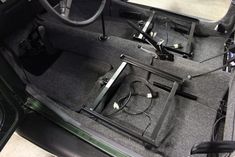 the inside of a car with its door open and wires in it's trunk