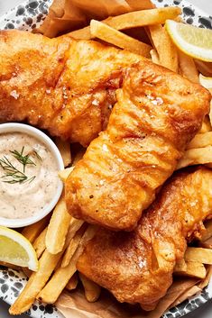 fish and chips on a plate with dipping sauce