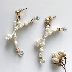 These handmade pearl, seashell and crystal bow earrings have are completely one-of-a-kind. Perfect to wear with any outfit for any occasion.  14k Gold Plated earring posts, genuine white freshwater pearl, crystal and seashell beads. Check out my Instagram account @innercurator for behind the scenes, discount codes and more. White Pearl Beaded Earrings For Gift, White Pearl Beaded Earrings As Gift, White Crystal Pearl Drop Earrings As Gift, Elegant Pearl Charm Earrings With Shell, Ocean-inspired Shell-shaped Pearl Earrings, Shell-shaped Pearl Earrings With Pearl Charm, Beach Shell-shaped Pearl Earrings, Pearl Seashell, Pearl Bow