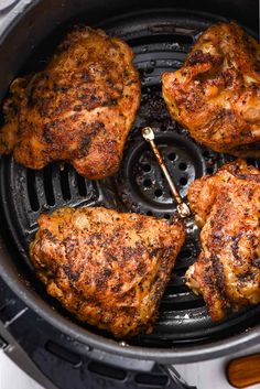 four pieces of chicken cooking in an air fryer