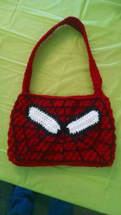 a crocheted spiderman purse sitting on top of a table