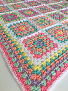 a multicolored crocheted blanket on a table