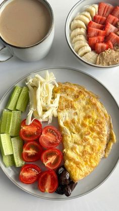 an omelet with fruit and vegetables on a plate next to a cup of coffee