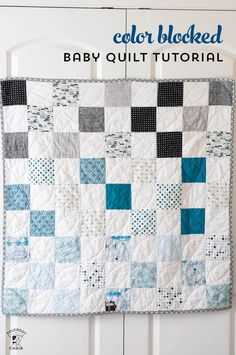 a baby quilt hanging on the wall with text overlay that reads, color blocked baby quilt