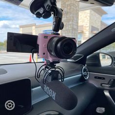 a dash camera mounted to the dashboard of a car with microphones in front of it