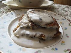 two pieces of food on a plate with a bowl and saucer in the background