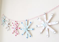 paper snowflakes are hanging on a string