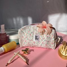 an assortment of beauty products on a pink surface