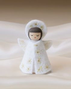 an angel doll is standing in the snow