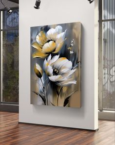 an abstract painting of white and yellow flowers in front of a large window with wooden flooring