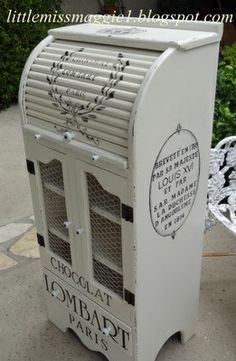 a white metal mailbox sitting on top of a sidewalk