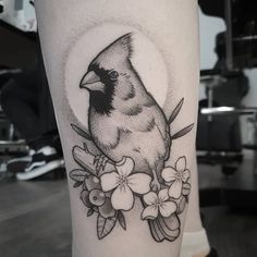 a bird sitting on top of a branch with flowers