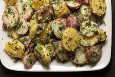 a white plate topped with potatoes covered in herbs