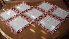 four pink and white place mats on a table