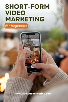 a woman holding up her cell phone to take a photo with the text short - form video marketing for beginners