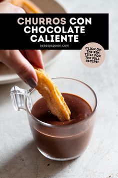 a person dipping chocolate into a glass cup with a piece of bread sticking out of it