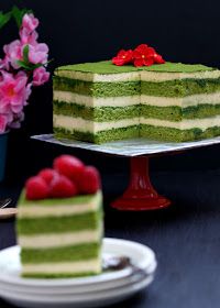 there is a cake with green and white frosting on the plate next to it