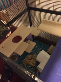 a small cage with some food inside of it and other things in the room around it