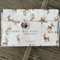 a sheet with deers on it sitting on top of a wooden floor next to a tag