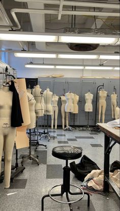 a room filled with lots of mannequins and tables