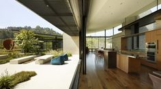 an open kitchen and dining area with wood flooring on the side of the house