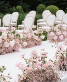 rows of white chairs with pink flowers on them