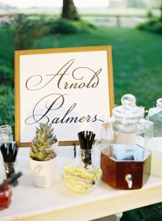 a table topped with lots of different types of food and drink bottles next to a sign that says aroob palmers