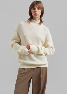 Color: Ecru Midweight wool blend fabric Relaxed fit Turtleneck Drop shoulders Rib knit Slip on style 50% Wool 50% Acrylic Dry Clean By Amomento. Imported Cream Polo Sweater For Winter, Winter Cream Polo Sweater, Beige Merino Wool Sweater For Fall, Beige Turtleneck Sweater For Work, Cream Polo Sweater For Workwear In Fall, Cream Polo Sweater For Fall Workwear, Beige Merino Wool Top For Fall, Fall Beige Merino Wool Tops, Cream Polo Sweater For Work In Winter