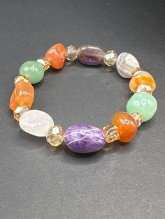 This beautifully crafted beaded bracelet features an array of healing crystals, including amethyst, rose quartz, carnelian, and green aventurine. Each gemstone is thoughtfully chosen for its unique properties to help support your emotional and spiritual well-being. Amethyst promotes peace, clarity, and balance, while rose quartz encourages love and compassion. Carnelian is the stone of motivation and creativity, giving you the confidence to pursue your passions. Green aventurine is known for attracting luck, new opportunities, and positive change. With its vibrant beads and subtle elegance, this bracelet is perfect for adding a touch of energy and color to any outfit. The handcrafted design makes it comfortable for everyday wear or as a statement piece. Whether you're looking for healing e Multicolor Amethyst Natural Stones Bracelet, Multicolor Amethyst Gemstones For Healing, Multicolor Amethyst Bracelets With Natural Stones, Healing Carnelian Beaded Bracelets With Natural Stones, Multicolor Amethyst Gemstone Beaded Bracelets, Multicolor Amethyst Beaded Bracelets With Natural Stones, Multicolor Crystal Bracelet With Natural Stones For Healing, Bohemian Aventurine Bracelet With Natural Stones, Bohemian Aventurine Crystal Bracelet With Gemstone Beads