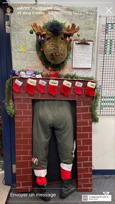 a fake fireplace with christmas stockings on it's legs and reindeer head above the fire